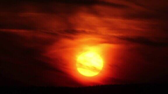 太阳穿过云层落下红色的天空