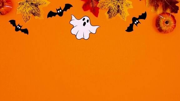 令人毛骨悚然的万圣节秋叶、鬼魂和蝙蝠出现在橙色主题的顶部停止运动