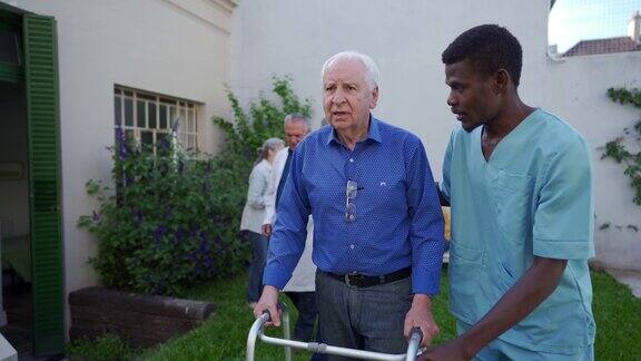 黑人医疗保健工作者帮助老年人在户外行走