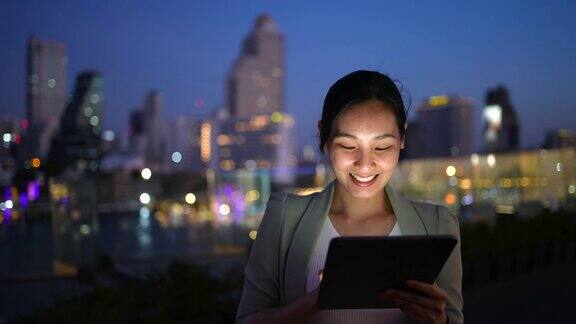 亚洲女商人在晚上使用智能设备