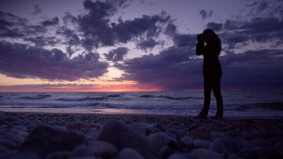 日落时分摄影师在海滩上剪影