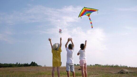 无忧无虑的孩子们朋友们喜欢户外娱乐在阳光明媚的周末在森林里的林间空地上玩风筝