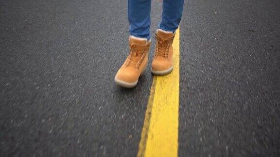 少年穿着黄色的靴子走在路上