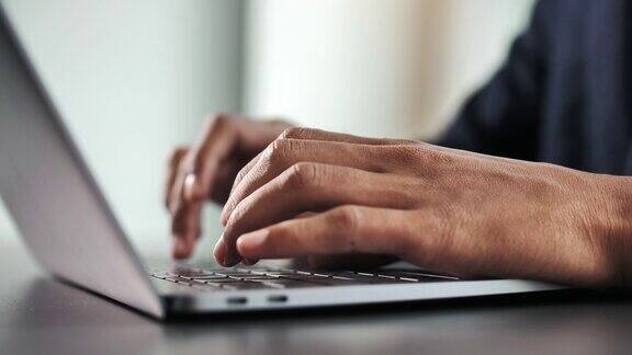 男人的手在笔记本电脑上打字