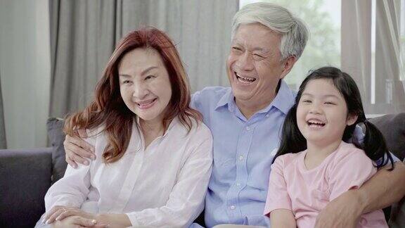 4K分辨率幸福的亚洲家庭和老年夫妇生活方式爷爷、奶奶、孙女在客厅里大笑关系