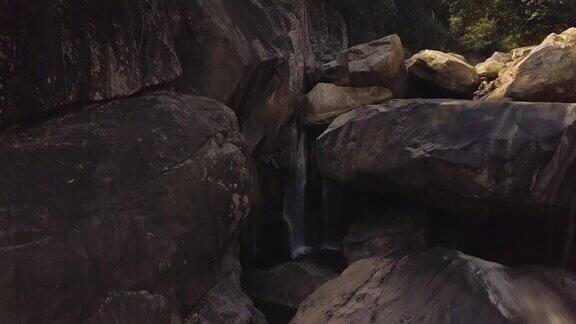 岩石瀑布在山区河流空中景观流动的河水在山上瀑布在野生森林无人机观看巨石和山川溪流