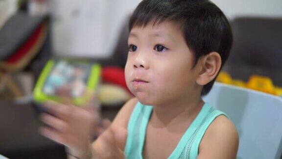 那个小男孩用勺子吃米饭