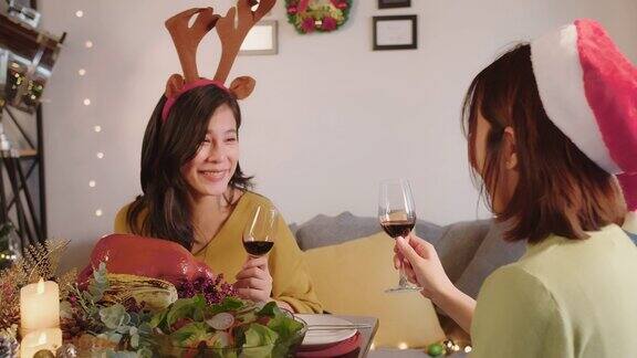 肖像一群亚洲快乐的朋友聚在一起庆祝喝着桌上的红酒享受节日新年或平安夜的晚宴一起在家里谈笑风生