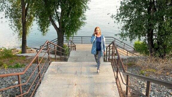 一个女人从河边走上楼梯