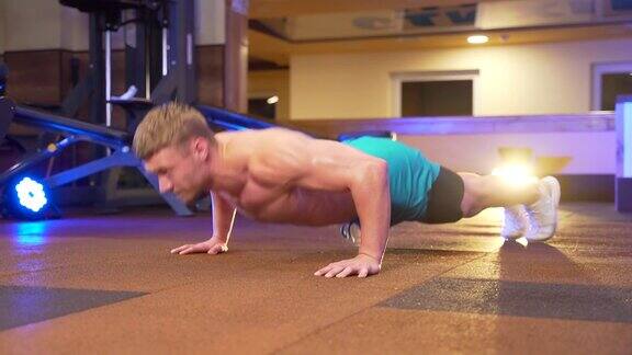 健美运动员在健身房的地板上做俯卧撑