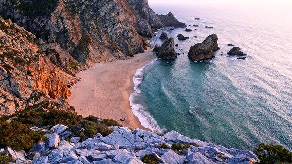 葡萄牙辛特拉的普拉亚达熊沙海滩和海浪的4K日落镜头