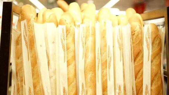 面包房柜台上一堆新鲜出炉的法式长棍面包商店橱窗上新鲜可口的面包