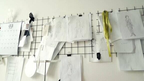 服装设计草图黑白模板和图纸钉在工作室的白墙上策划新服装收藏创意思维理念