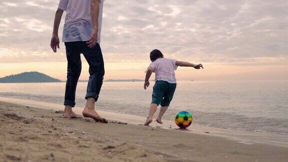 亚洲父子在沙滩上玩球
