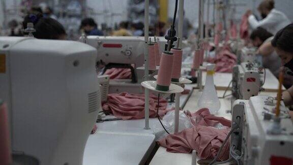 拉丁美洲的女蓝领工人在服装厂各自的工作站工作