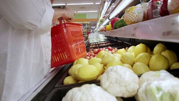 新常态保持社交距离亚洲女性戴着防护口罩在超市选购水果新冠肺炎疫情爆发后女性在超市推着购物车购物