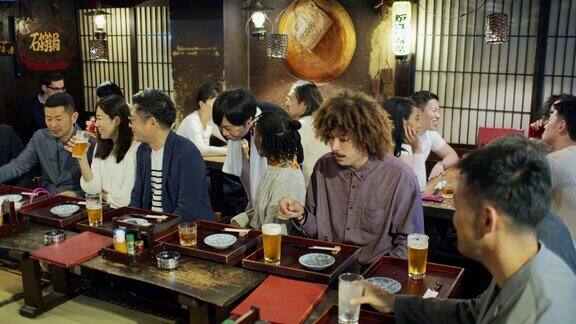 跟踪镜头跟踪服务员穿过拥挤的东京餐厅