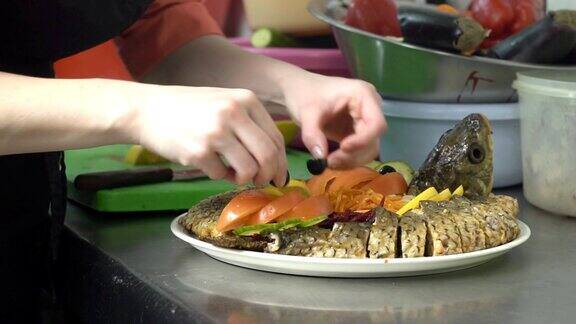 厨师用柠檬和蔬菜装饰烤鱼慢动作慢动作美味