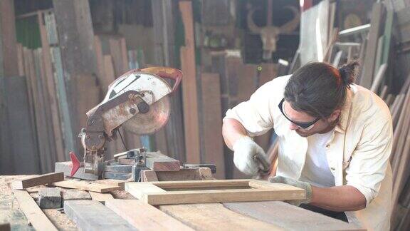木匠在车间工作他在锯一块木板