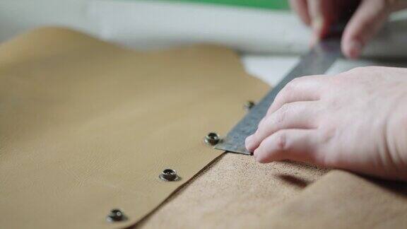 鞣皮手用尺子测量皮革制品上的金属纽扣