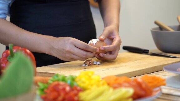 镜头镜头特写亚洲妇女的手剥煮鸡蛋在厨房的木板上准备和烹饪食物健康和生活方式