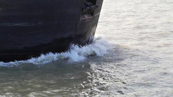 这艘货轮的船头在黄浦江中航行货船的机头切入水面在水面上产生小波浪动作非常缓慢