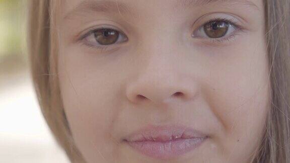 一个可爱的棕色眼睛的小女孩的特写黑发微笑的镜头