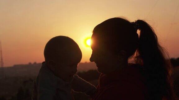 夕阳西下的田野上母子剪影幸福的家庭观念