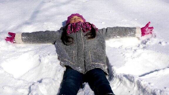 快乐的小女孩做雪天使