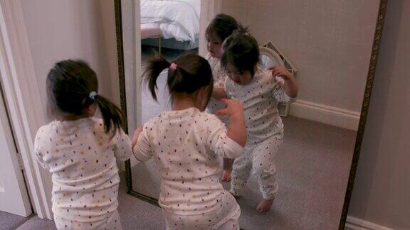 一对双胞胎姐妹在家里一起照镜子
