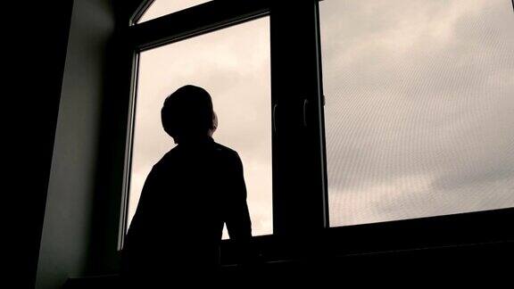 男孩站在窗前看着天空