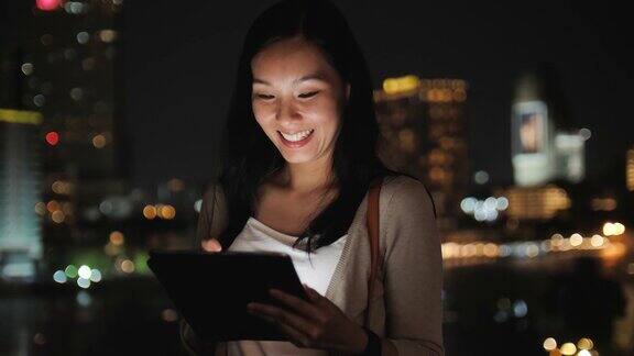 亚洲女性在晚上使用数码平板电脑