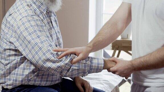 按摩师检查一个老人的手腕和手肘的疼痛