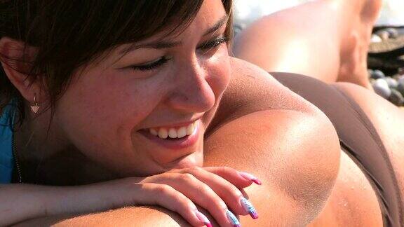 高清特写年轻美丽的女人在海滩上晒太阳