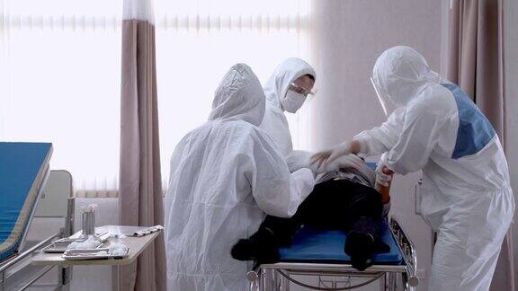 医生和护士正在检查患者该患者突然发病并瘫倒在病床上患有Covid-19和冠状病毒病