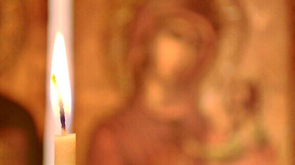 蜡烛在背景的圣母玛利亚的图标