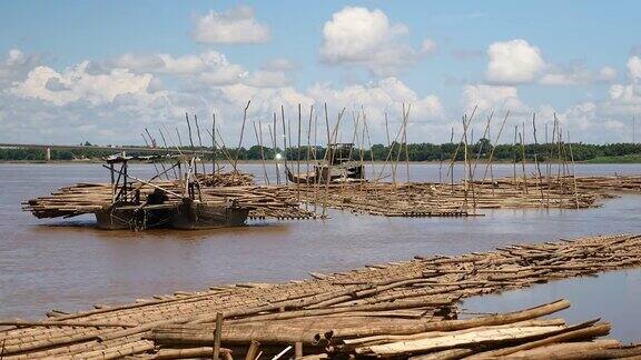 竹竿横放在驳船上竹地板在插在河床上的长竹竿之间