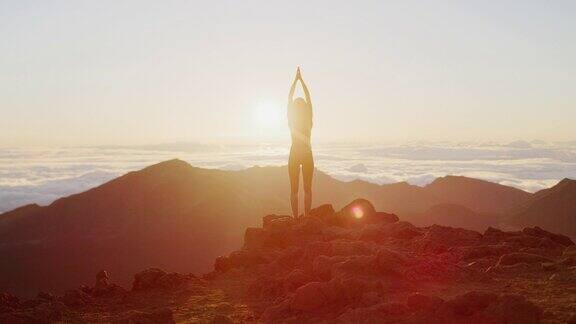 日出时女人在山上练习瑜伽