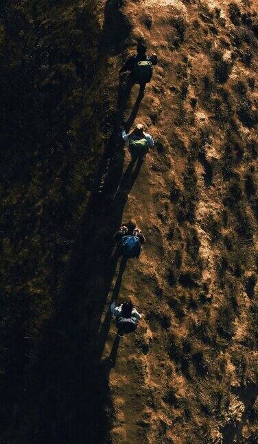 四个背着背包的旅行者走在山上