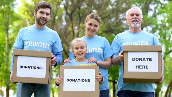 微笑的志愿者拿着捐款箱看着相机慈善项目帮助