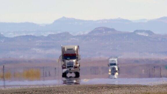炎热的雾霾扭曲了半卡车在阳光明媚的一天沿着被群山环绕的犹他州州际公路行驶的视频