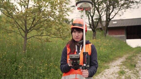 女性土地测量员用全站仪测量土地