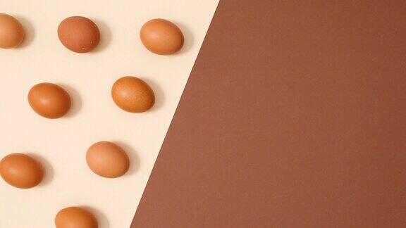 创意的有机鸡蛋的平面格局出现在裸棕色的背景停止运动