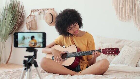 女博主在智能手机上录制吉他课程视频