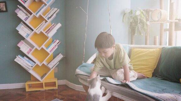 小男孩和他的猫在家里玩