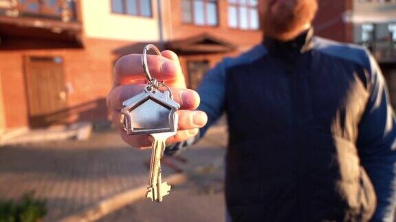 男性手握钥匙在新家前销售