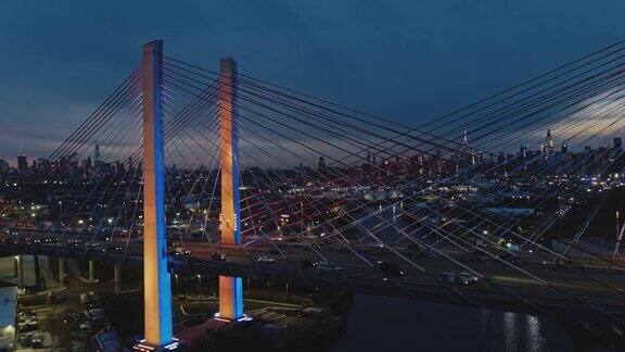 鸟瞰图的照明科修斯科大桥在黄昏与曼哈顿和布鲁克林在威廉斯堡工业区的远景无人机视频与向前摄像机运动