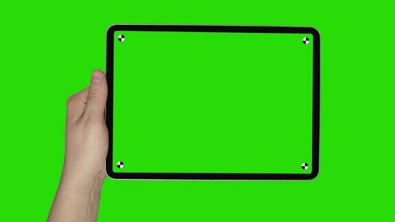 男性手持平板在绿色屏幕背景景观与跟踪合成4k