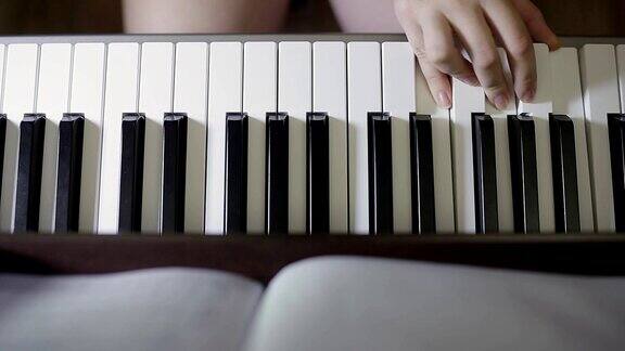 手在数字钢琴键盘上弹奏的少女