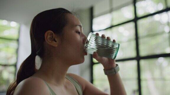 运动女性在运动后在家喝水